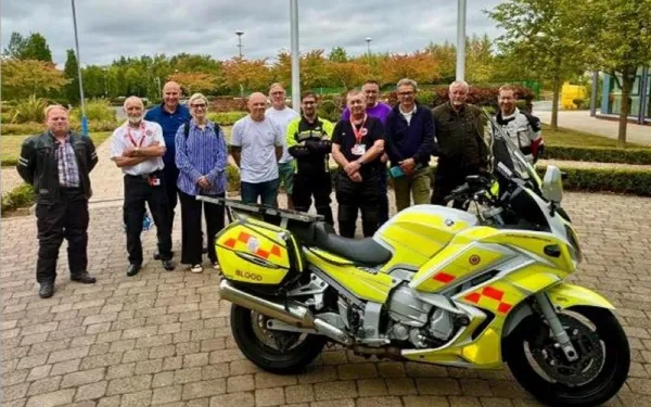 Photo of New Members at an NBB induction session with a blood bike in the foreground